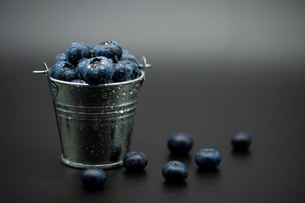 Nahaufnahme eines Haufens frischer Blaubeeren in einem kleinen Eimer