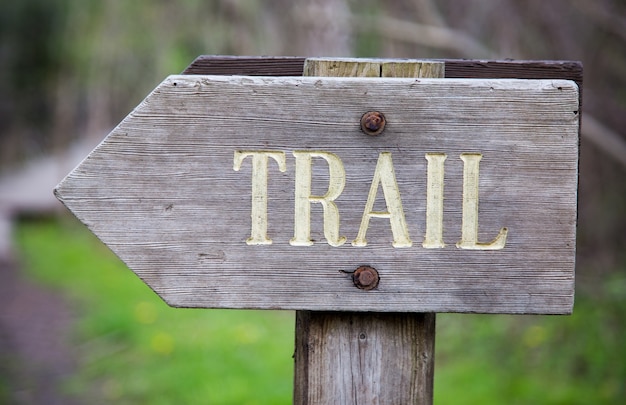 Nahaufnahme eines Holzschildes mit dem darauf geschriebenen Wort [TRAIL]