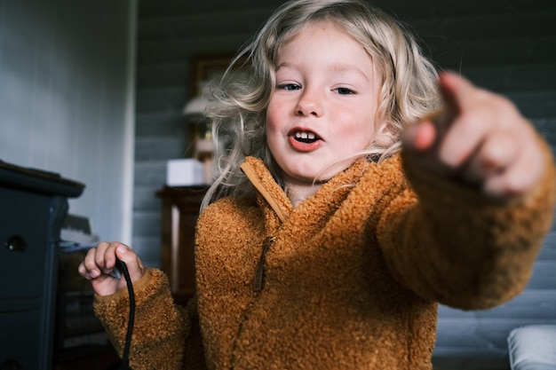 Nahaufnahme eines jungen blonden Mädchens, das einen braunen Wintermantel trägt