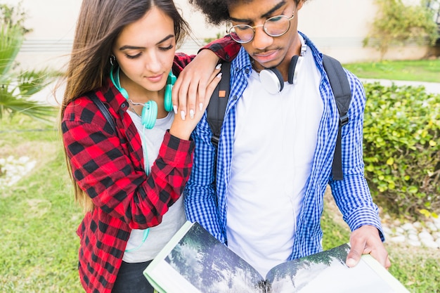 Nahaufnahme eines jungen Mannes und der Studentinnen, die die Bücher im Park lesen