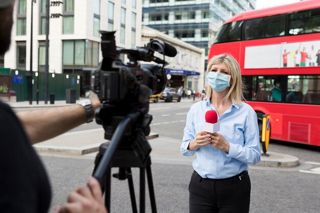 Nahaufnahme eines jungen Reporters, der eine Situation live beschreibt