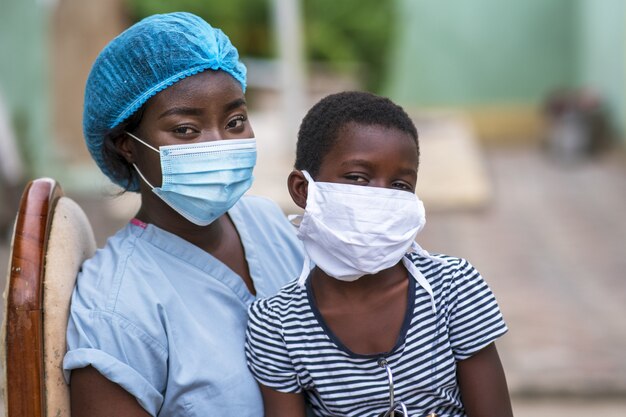 Nahaufnahme eines Jungen und eines Arztes mit Hygienemasken