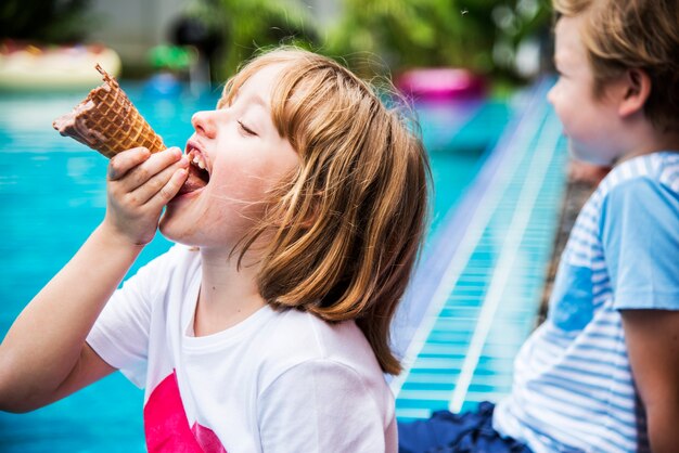 Nahaufnahme eines kaukasischen Mädchens, das Eis am Pool isst?