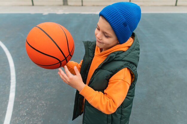 Nahaufnahme eines kleinen Jungen, der Basketball spielt
