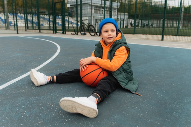 Kostenloses Foto nahaufnahme eines kleinen jungen, der basketball spielt