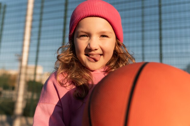 Nahaufnahme eines kleinen Mädchens, das Basketball spielt