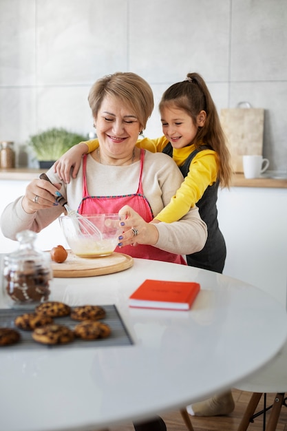 Kostenloses Foto nahaufnahme eines mädchens, das mit ihrer großmutter kocht