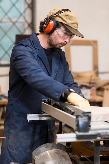 Kostenloses Foto nahaufnahme eines männlichen tischlers, der in der werkstatt arbeitet