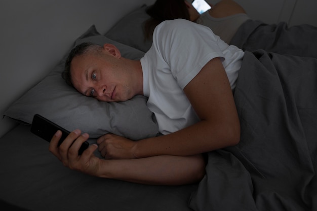 Nahaufnahme eines Mannes am Telefon im Schlafzimmer