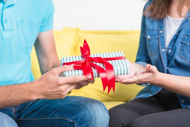 Nahaufnahme eines Mannes, der seiner Freundin Valentinsgrußgeschenk gibt