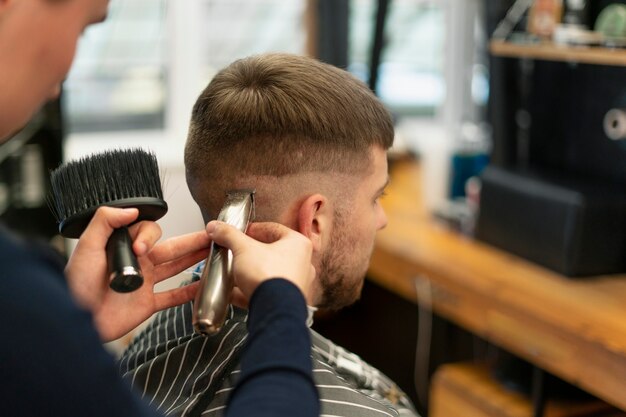 Nahaufnahme eines Mannes, der sich im Salon die Haare schneiden lässt