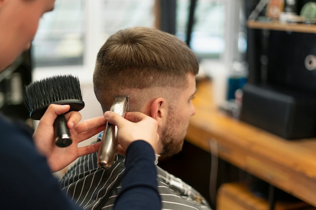 Nahaufnahme eines Mannes, der sich im Salon die Haare schneiden lässt