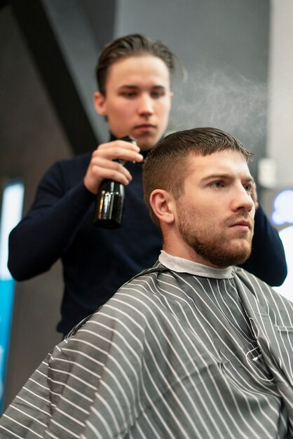 Nahaufnahme eines Mannes, der sich im Salon die Haare schneiden lässt