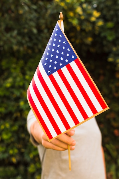 Nahaufnahme eines Mannes, der USA-Flagge vor seinem Gesicht hält