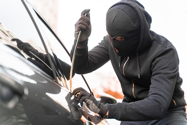 Kostenloses Foto nahaufnahme eines mannes, der versucht, in ein auto einzubrechen