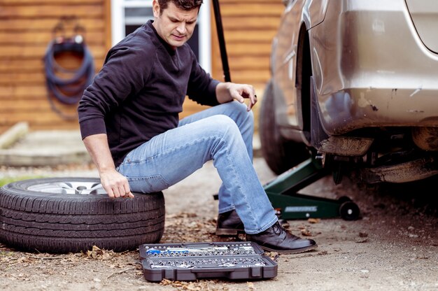 Nahaufnahme eines Mechanikers, der versucht, ein Auto mit Spezialwerkzeugen zu reparieren