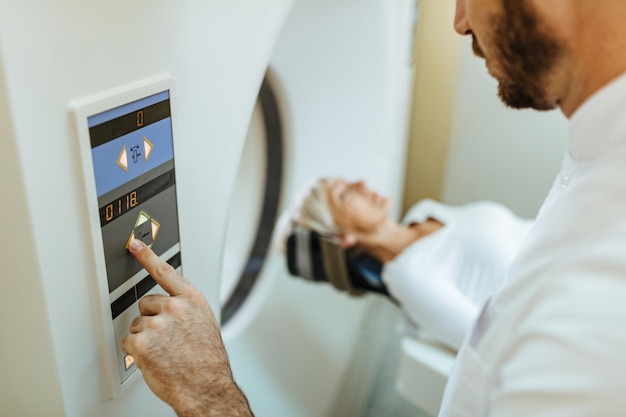 Nahaufnahme eines Medizintechnikers, der eine MRT-Scan-Untersuchung eines Patienten im Krankenhaus beginnt