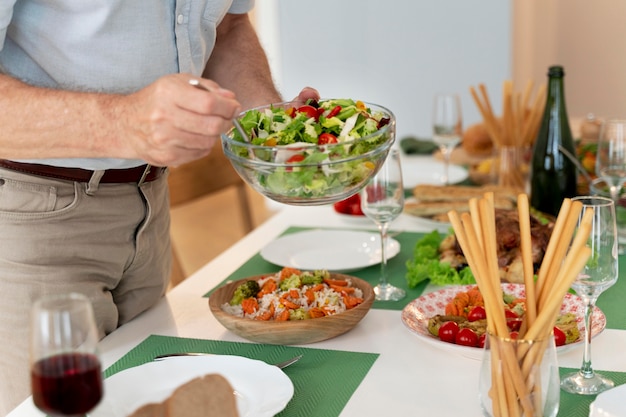 Nahaufnahme eines reifen Mannes, der das Abendessen für die Familie zubereitet