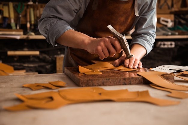 Nahaufnahme eines Schuhmachers, der mit Leder arbeitet