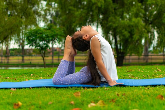 Nahaufnahme eines süßen lateinamerikanischen Mädchens, das Yoga in einem Park praktiziert?