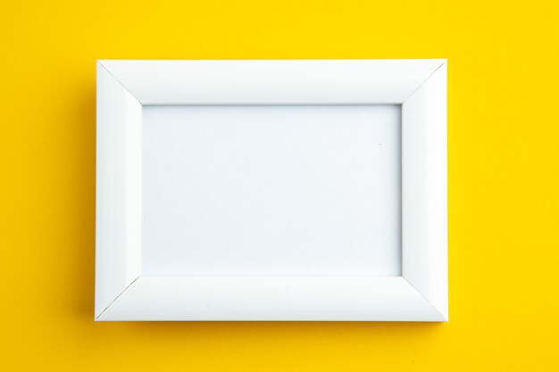 Nahaufnahme eines weißen leeren Bilderrahmens auf Gelb mit freiem Speicherplatz