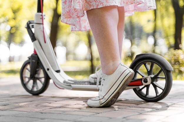 Nahaufnahme elegante Frau, die Roller reitet