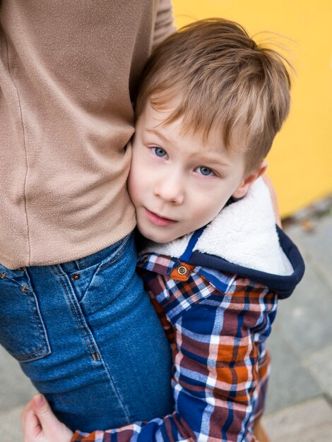 Nahaufnahme entzückender kleiner Junge, der seine Mutter hält