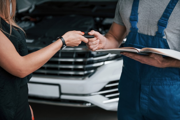 Nahaufnahme. Ergebnisse der Reparatur. Zuversichtlich Mann zeigt, welche Art von Schaden ihr Auto genommen wurde