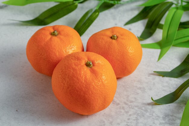 Nahaufnahme Foto von frischer Clementine Mandarine auf grauer Oberfläche.