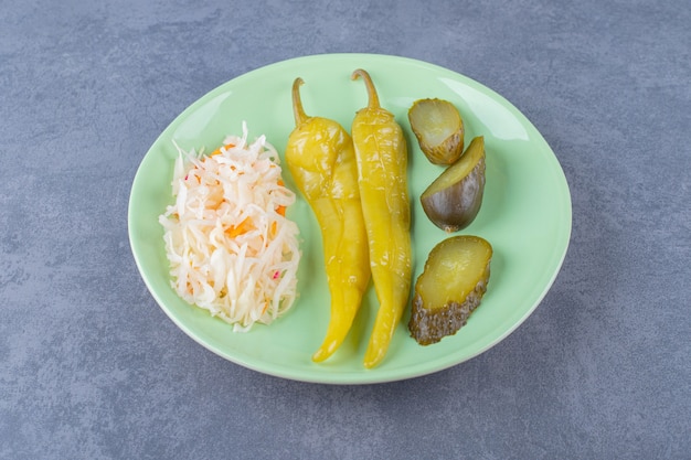 Nahaufnahme foto von sauerkraut mit pfeffer und gurkengurke.