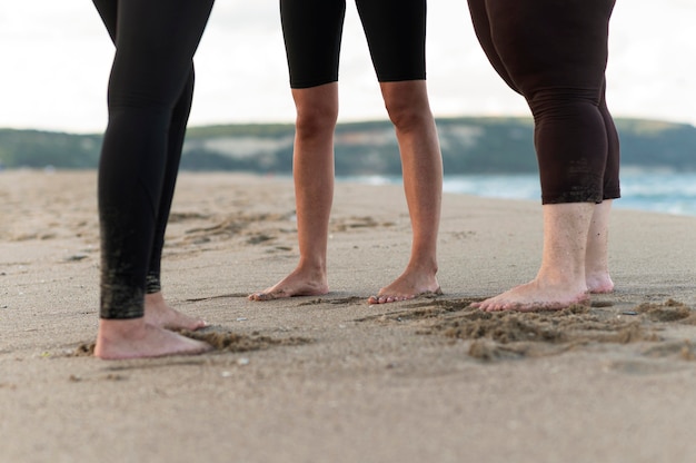 Nahaufnahme Freunde Füße auf Sand