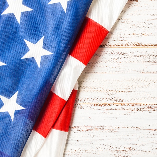 Nahaufnahme gefalteter USA-Flagge mit Streifen und Stern auf hölzernem Hintergrund