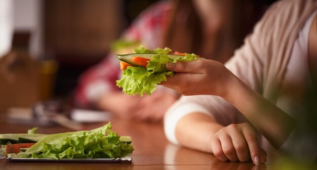 Nahaufnahme getöntes Bild eines vegetarischen Gerichts, das in jemandes Hand dargestellt wird Dame, die in einem vegetarischen Café oder Restaurant sitzt