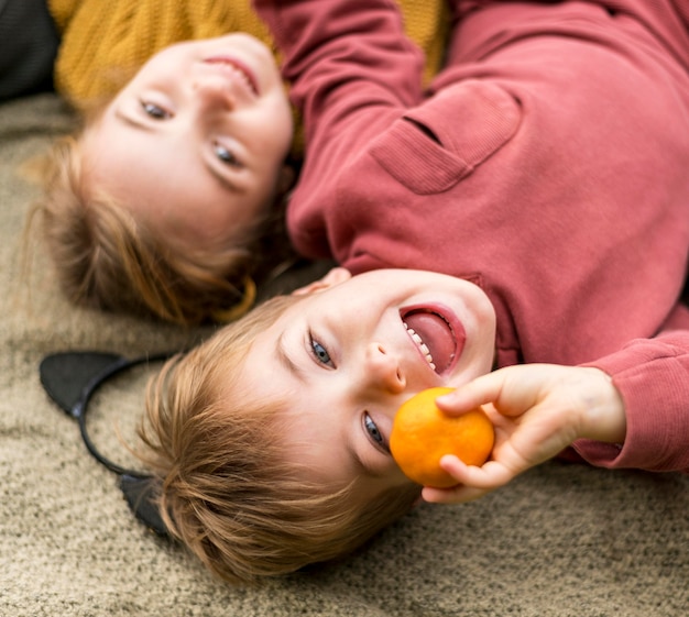 Nahaufnahme glückliche Kinder mit Clementine