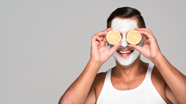 Nahaufnahme glücklicher Mann mit Gesichtsmaske und Zitrone