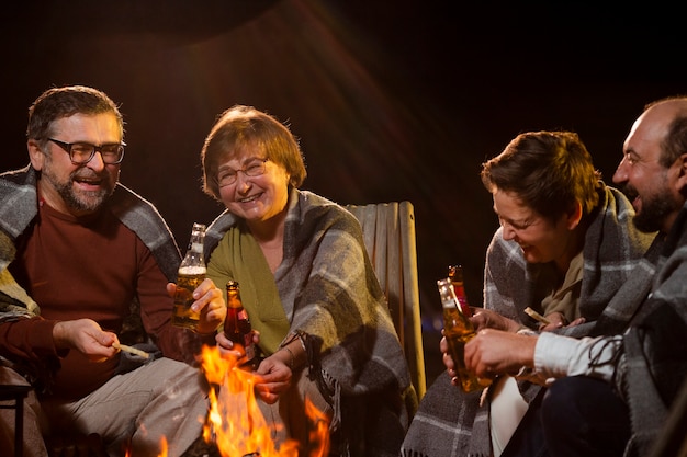 Nahaufnahme glücklicher Menschen, die am Feuer sitzen