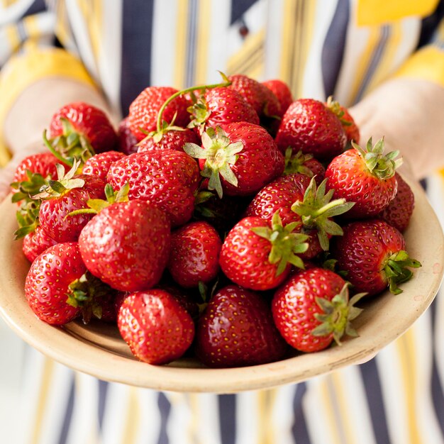 Nahaufnahme Großmutter, die Erdbeeren hält