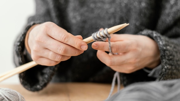 Nahaufnahme Hände, die Stricknadeln halten