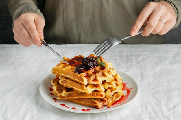 Nahaufnahme Hände, die Waffeln schneiden