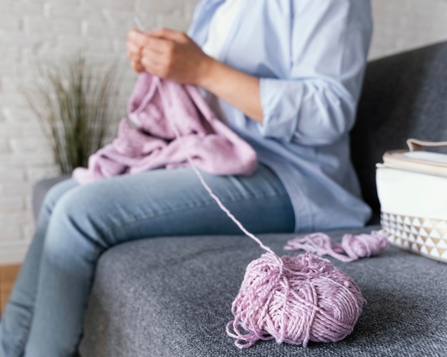 Nahaufnahme Hände stricken auf der Couch