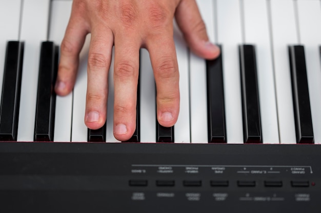 Nahaufnahme Hand auf Digitalpiano Draufsicht