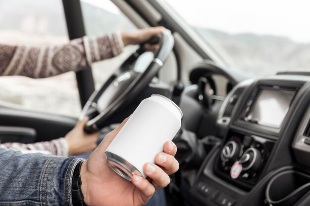 Nahaufnahme Hand, die Getränkedose im Auto hält