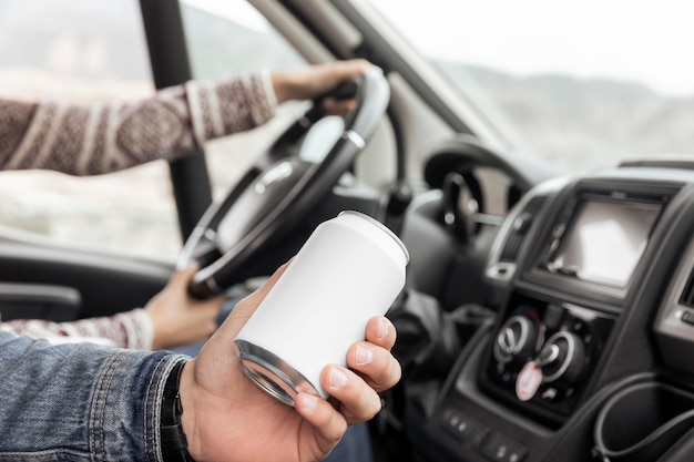 Nahaufnahme Hand, die Getränkedose im Auto hält