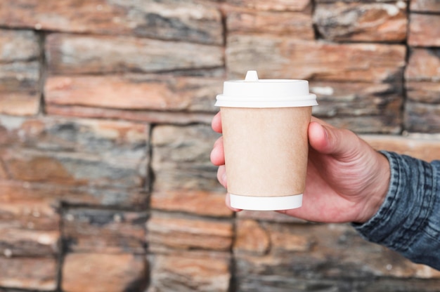 Kostenloses Foto nahaufnahme hand, die kaffeetasse hält