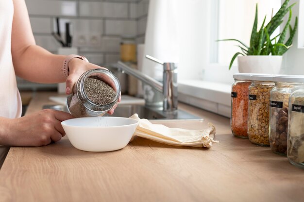 Nahaufnahme Hand, die Samen in Schüssel gießt