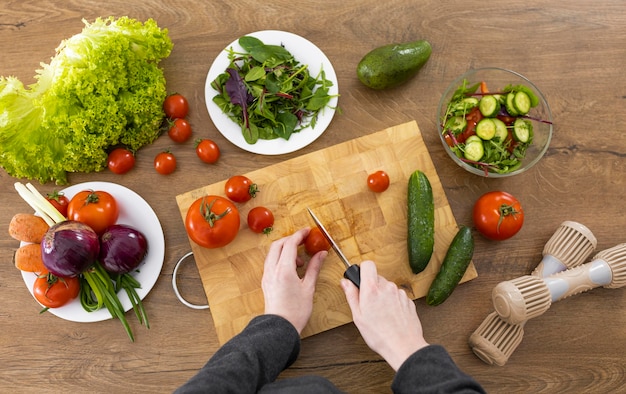 Nahaufnahme Hand, die Tomatenoberansicht schneidet