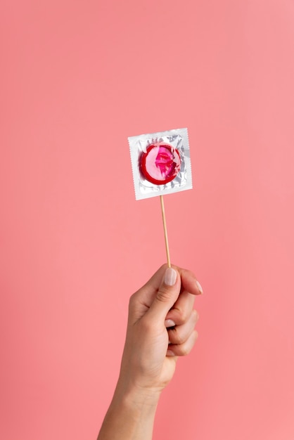 Kostenloses Foto nahaufnahme hand mit rotem kondom