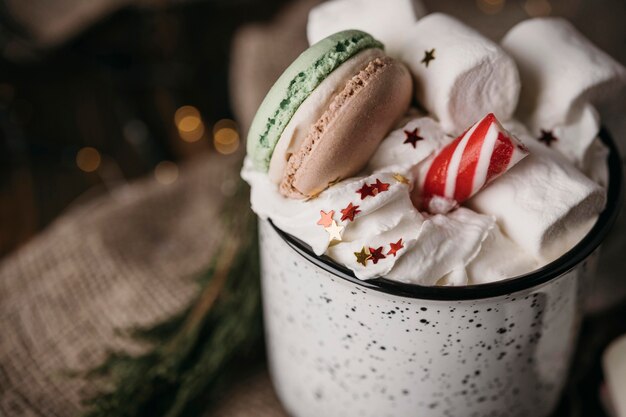 Nahaufnahme heiße Schokolade mit Schlagsahne, Marshmallows und Macarons