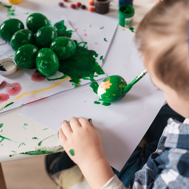 Kostenloses Foto nahaufnahme kleiner junge, der traditionelle eier für ostern malt