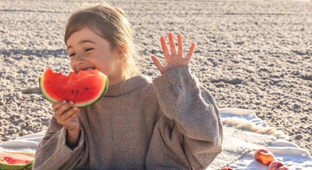 Nahaufnahme kleines Mädchen isst Wassermelone am Strand